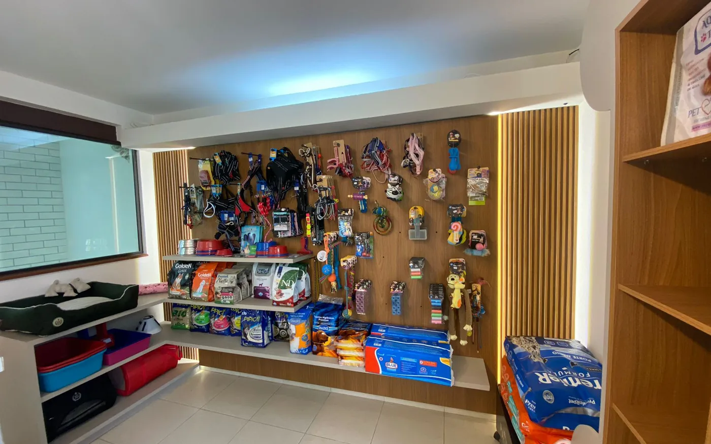 Parede de acessórios, coleiras, brinquedos e rações do pet shop Companhia Animal na Vila Mariana
